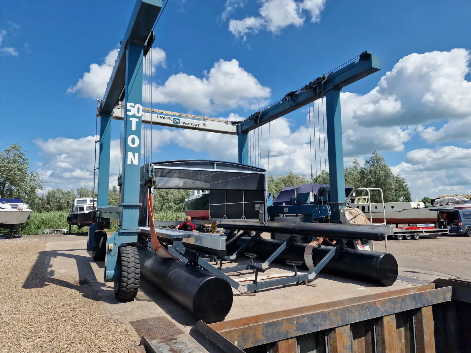 Boothuis met bootlift in een portaalkraan op de werf