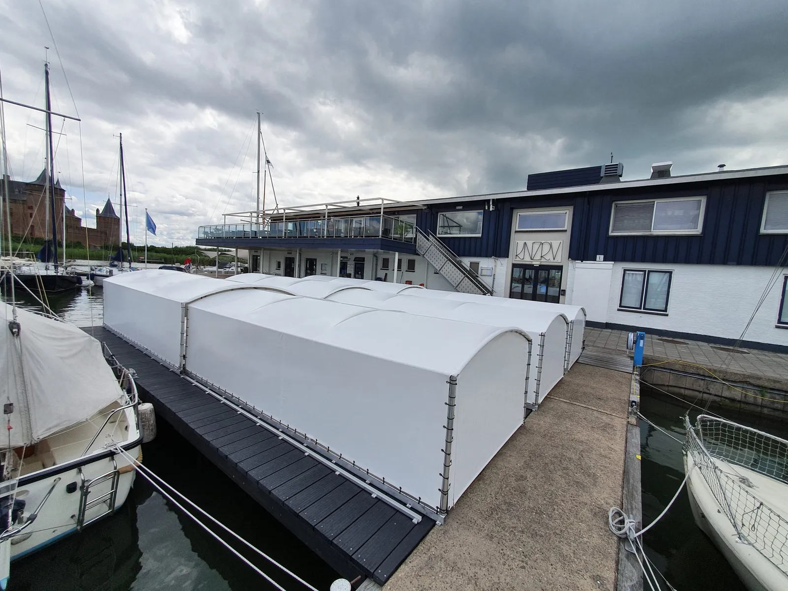 Rij witte bootoverkappingen aan een steiger in een jachthaven